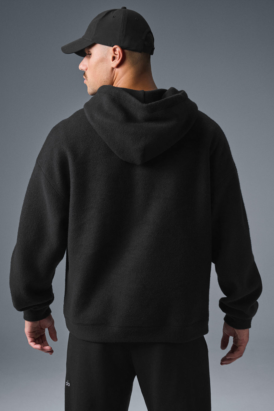 Model wearing black oversized hoodie with relaxed fit, hood up
