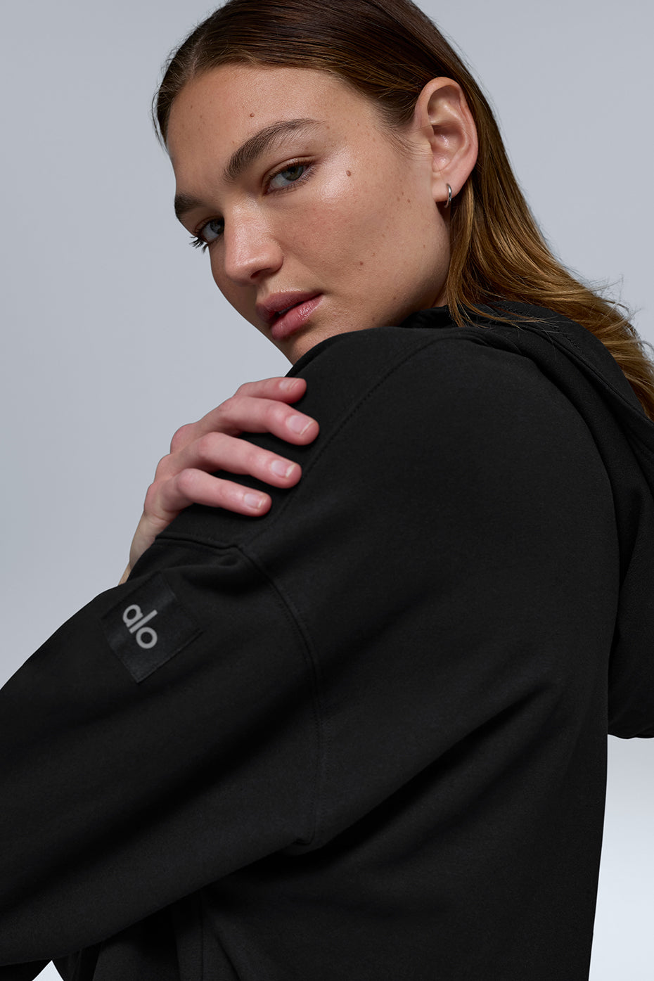 Model wearing hoodie with layered trench coat for urban style