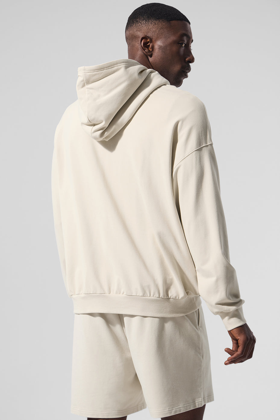 Side angle of the Essence Comfort Hoodie, highlighting its banded cuffs and hem.