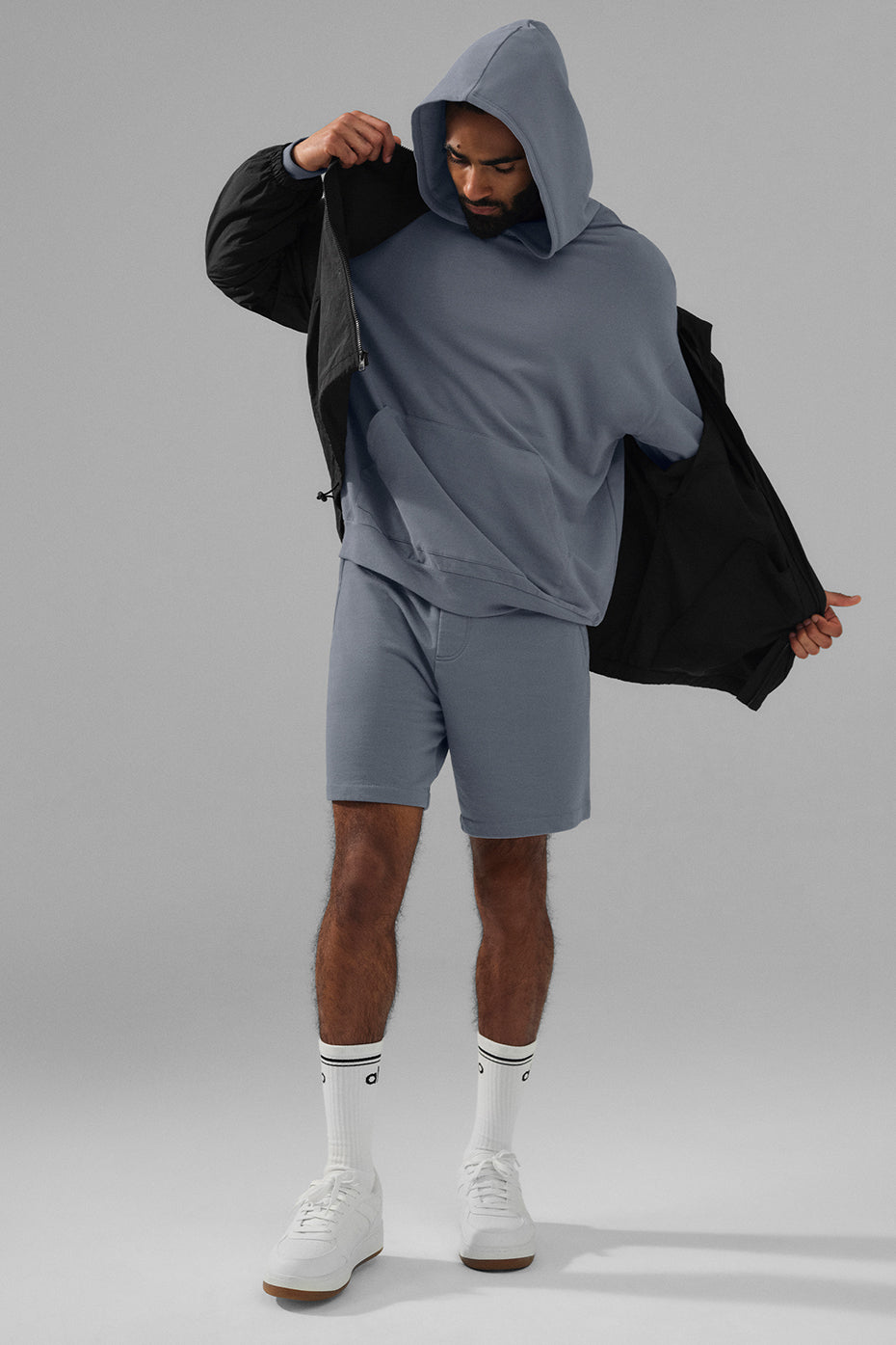 Detail shot of the kangaroo pocket on the grey hoodie, emphasizing comfort and practicality