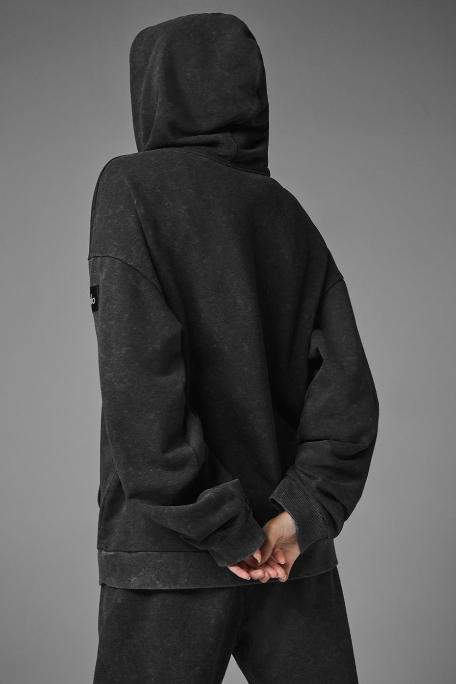 Back angle of oversized hoodie with ribbed hem and relaxed fit