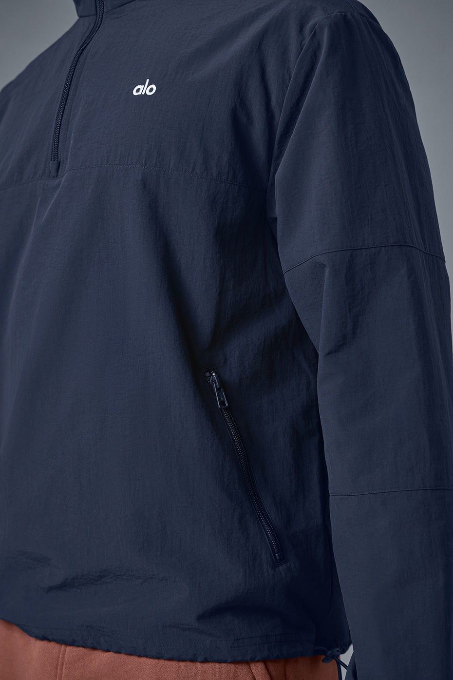 Navy quarter-zip pullover displayed on a hanger, showcasing its lightweight fabric.