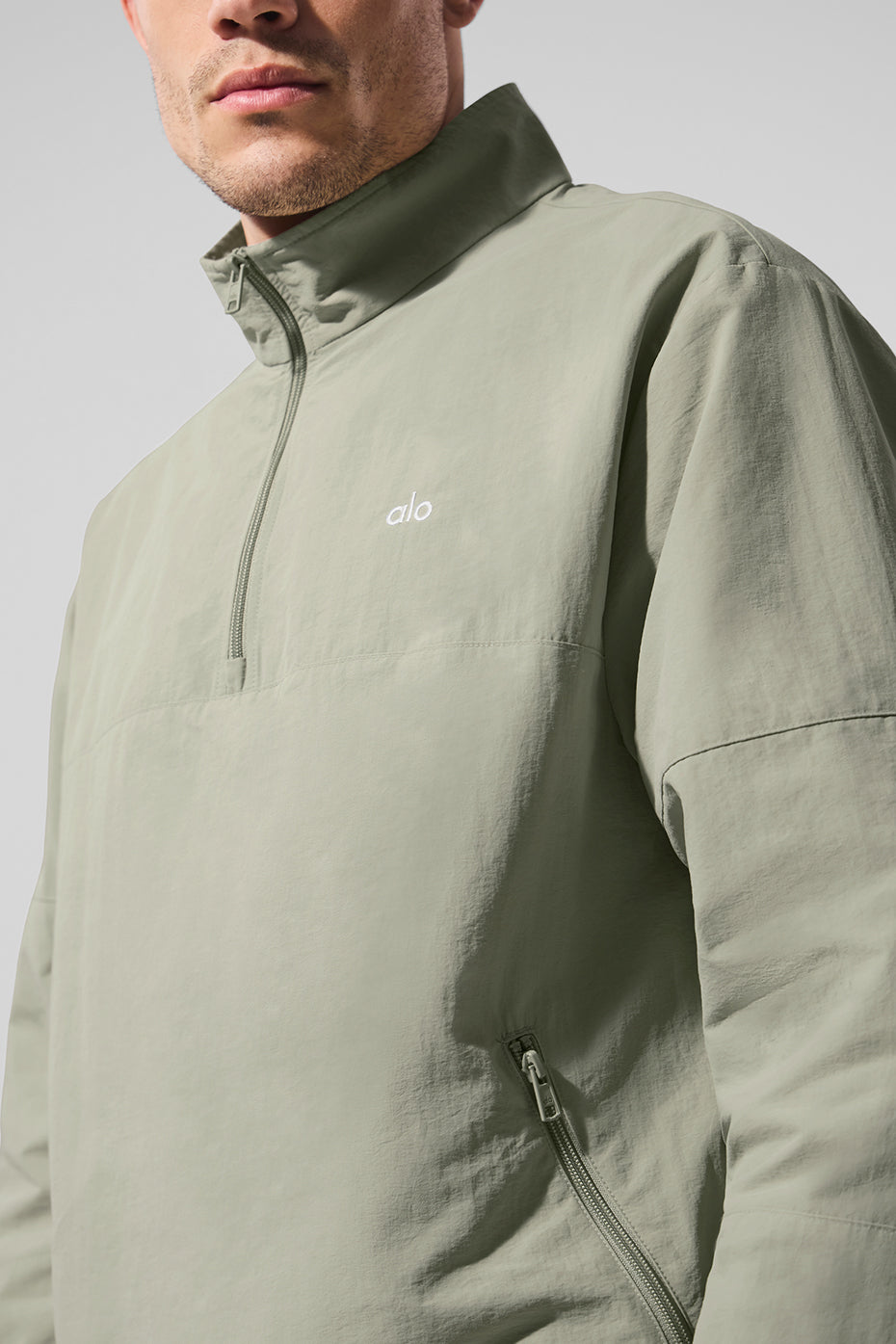 Side view of the quarter zip running top, highlighting the zippered pockets and stretchy cuffs.