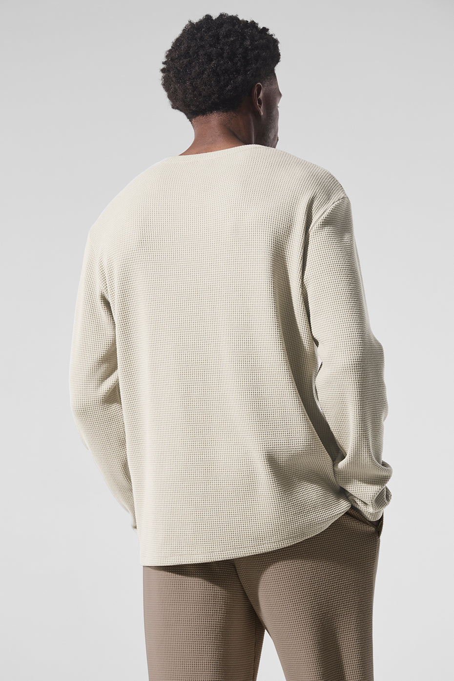 Close-up detail of crew neck shirt texture showing waffle knit pattern.