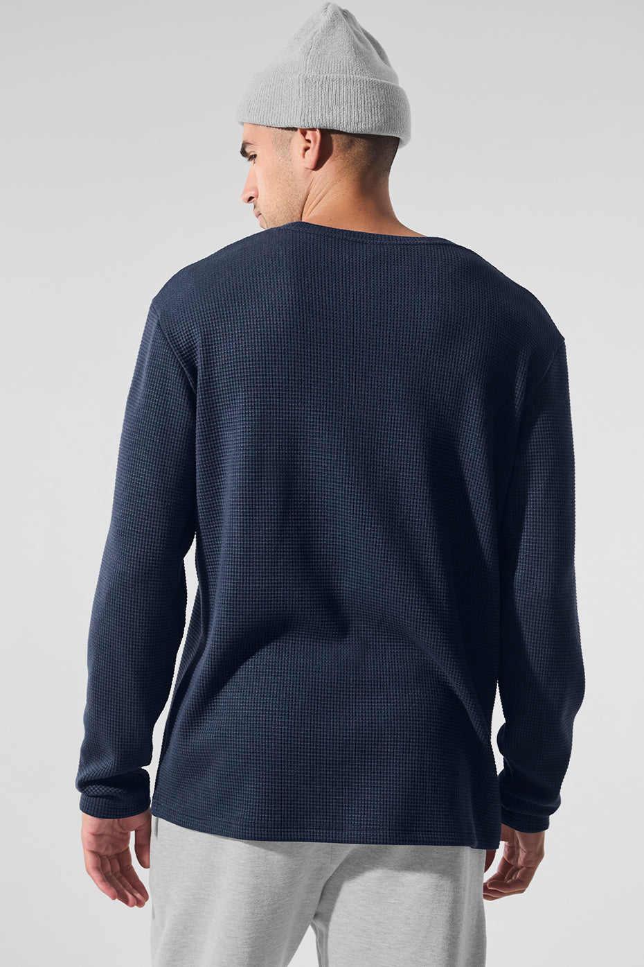 Front view of navy long sleeve shirt displayed with denim jeans
