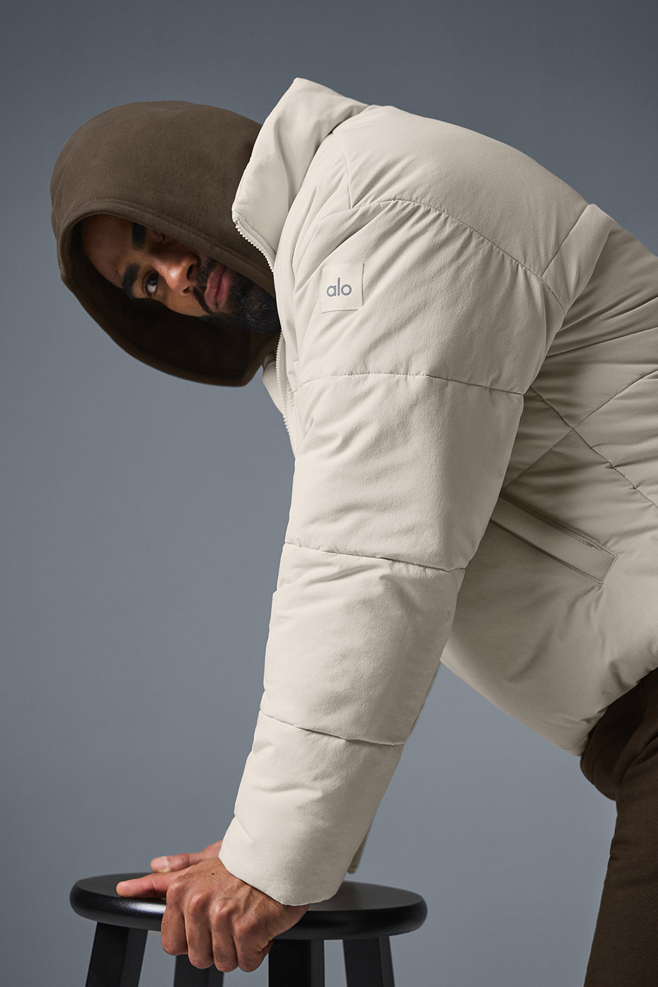 Close-up of full zip closure and pockets on a black puffer jacket