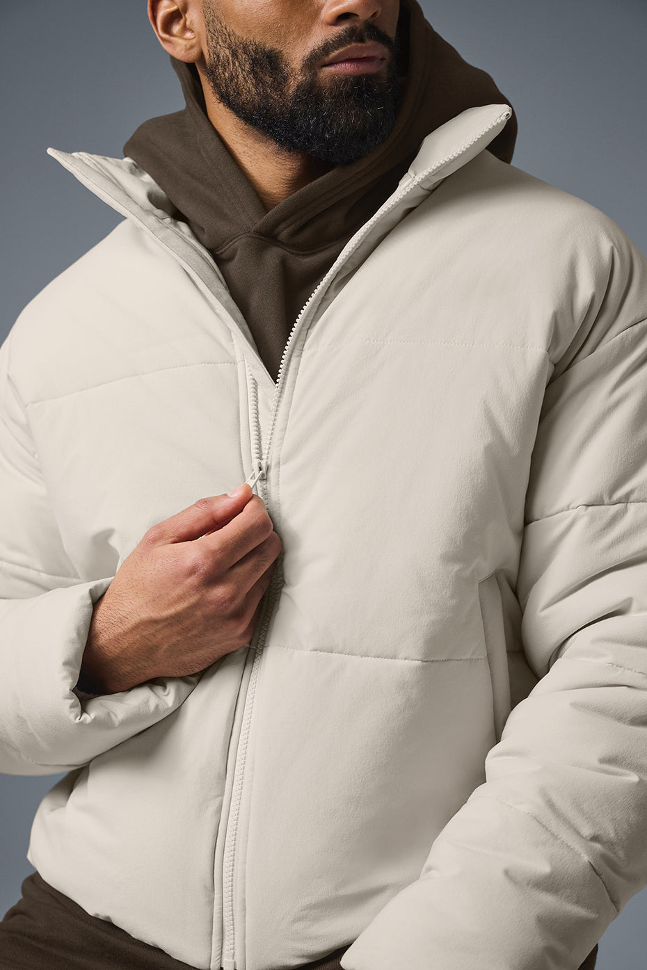 Model walking through snowy NYC street in a mens puffer jacket