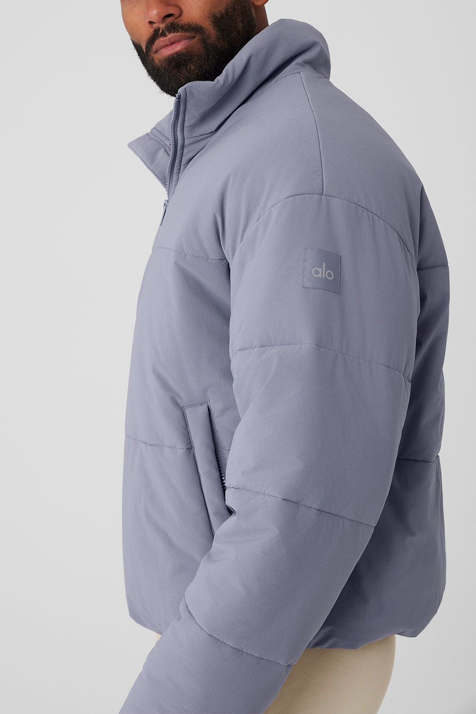 Close-up of the lightweight puffer jacket showing its textured woven fabric and zipper details
