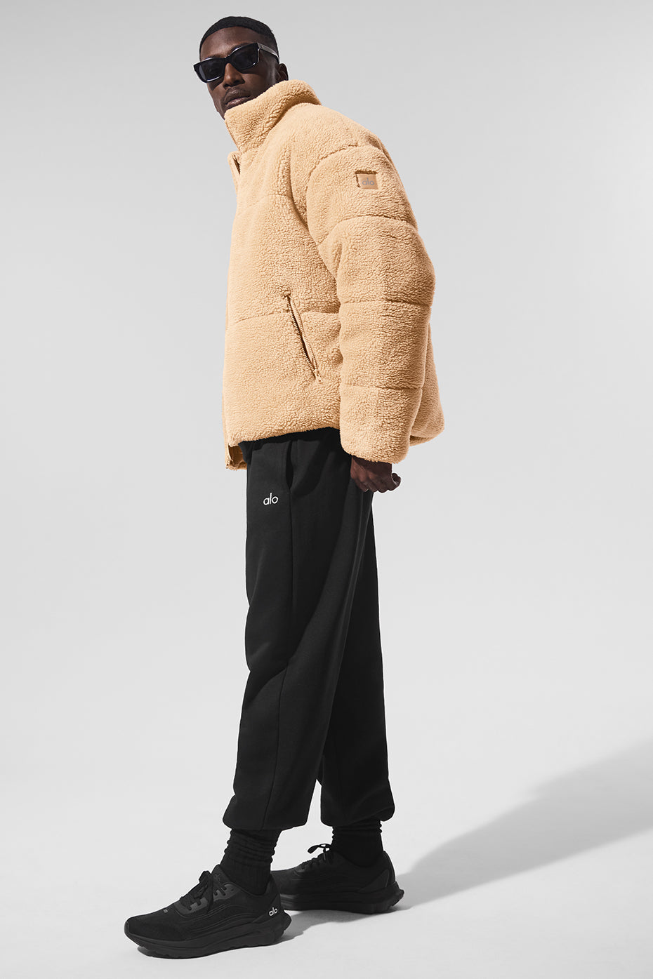 Zipper details and sherpa-lined collar on black puffer jacket