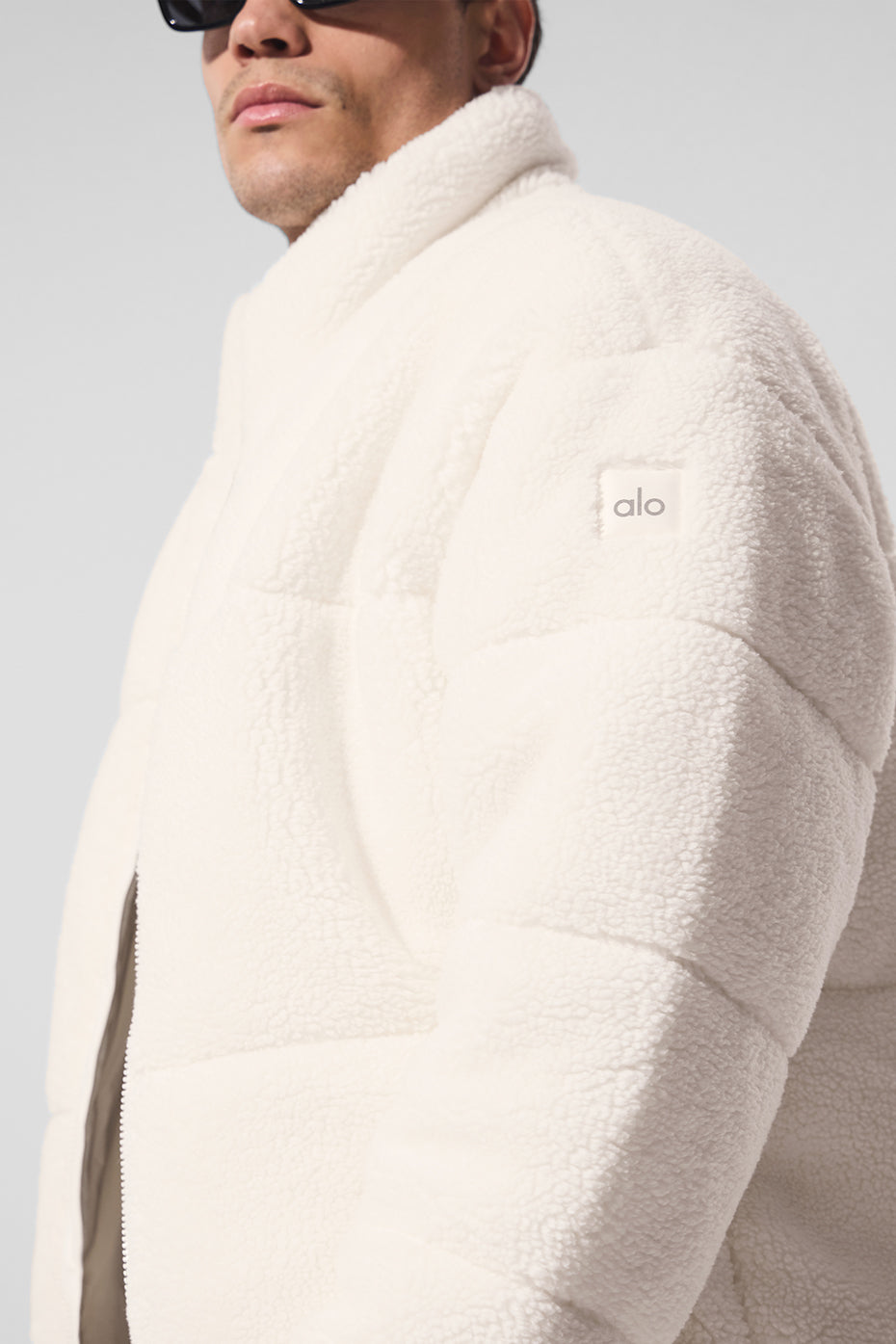 Model wearing the ivory sherpa puffer jacket in a winter setting.