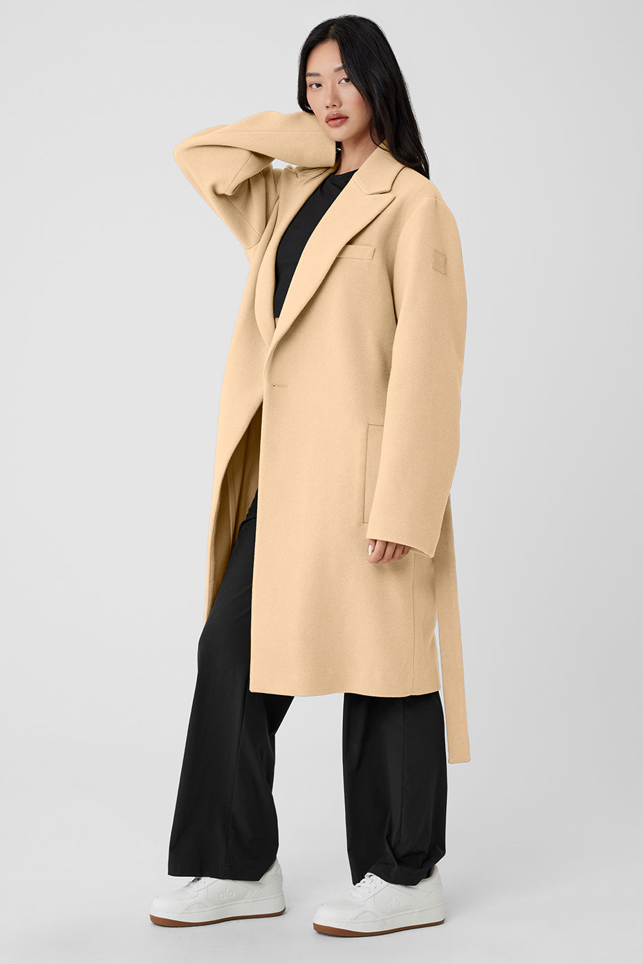 Woman’s trench coat styled with boots for a chic winter look