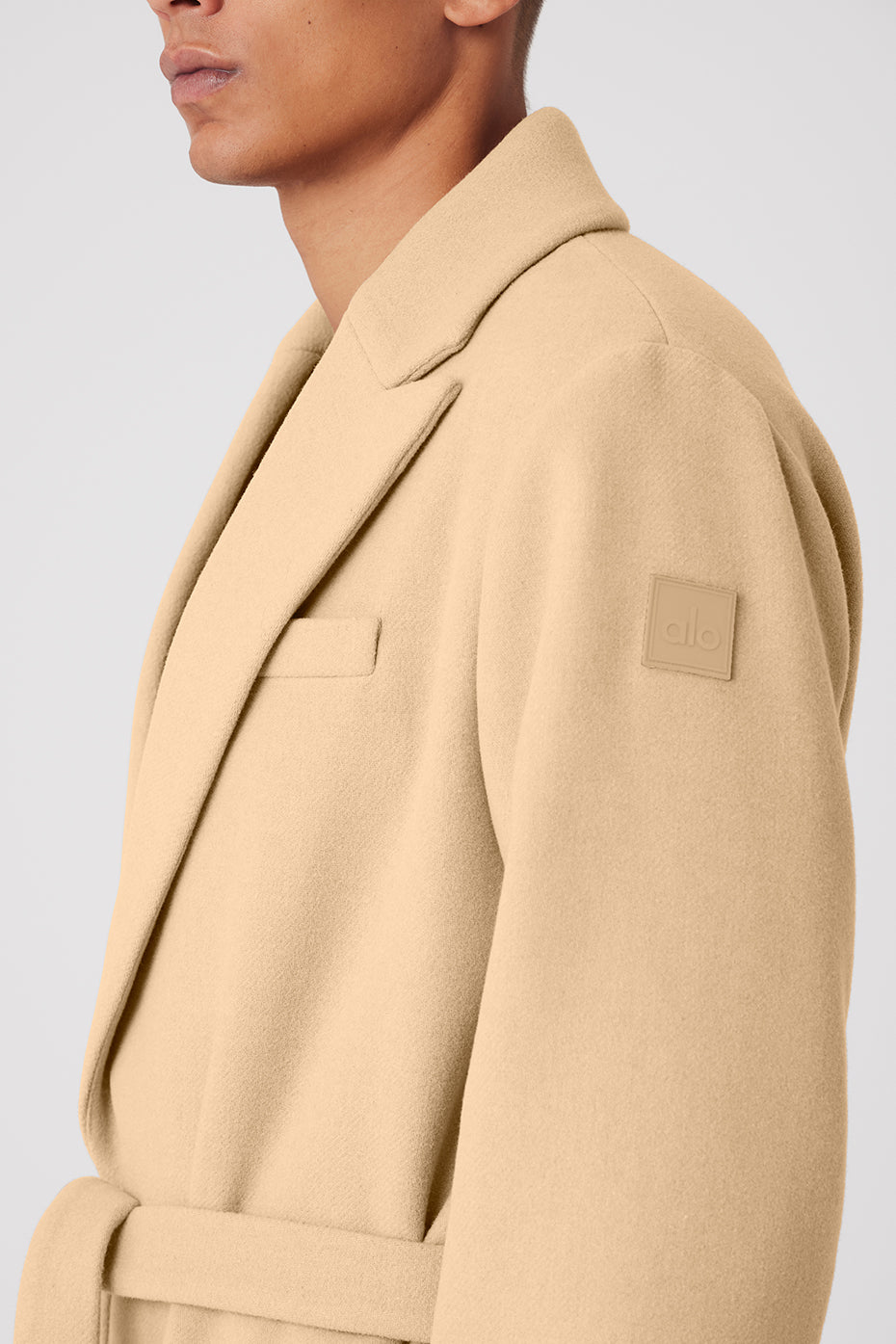 Close-up of mens wool coat lapels and button details, highlighting texture