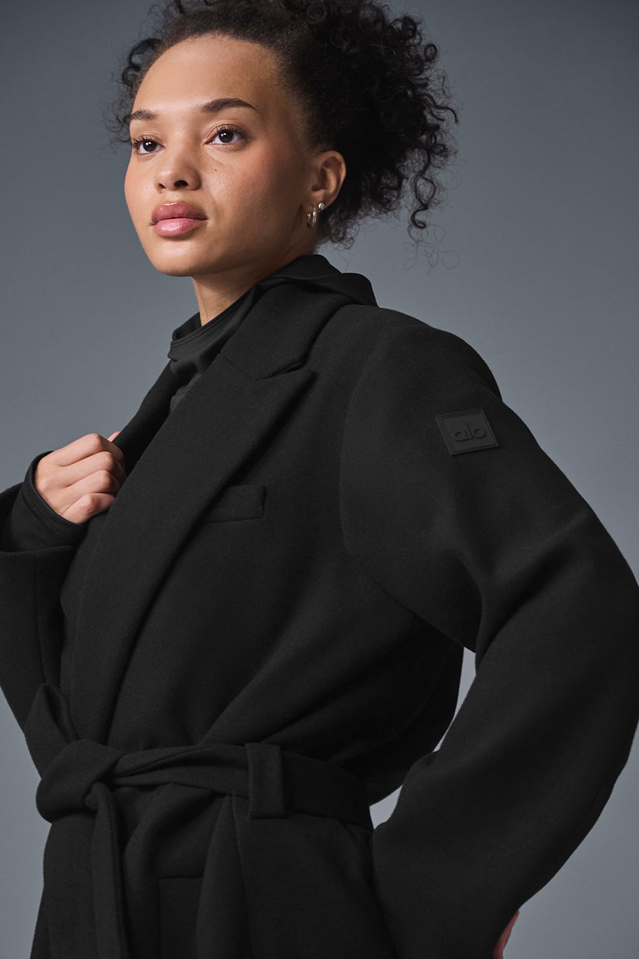 Front view of the black wool coat showcasing its tailored design.