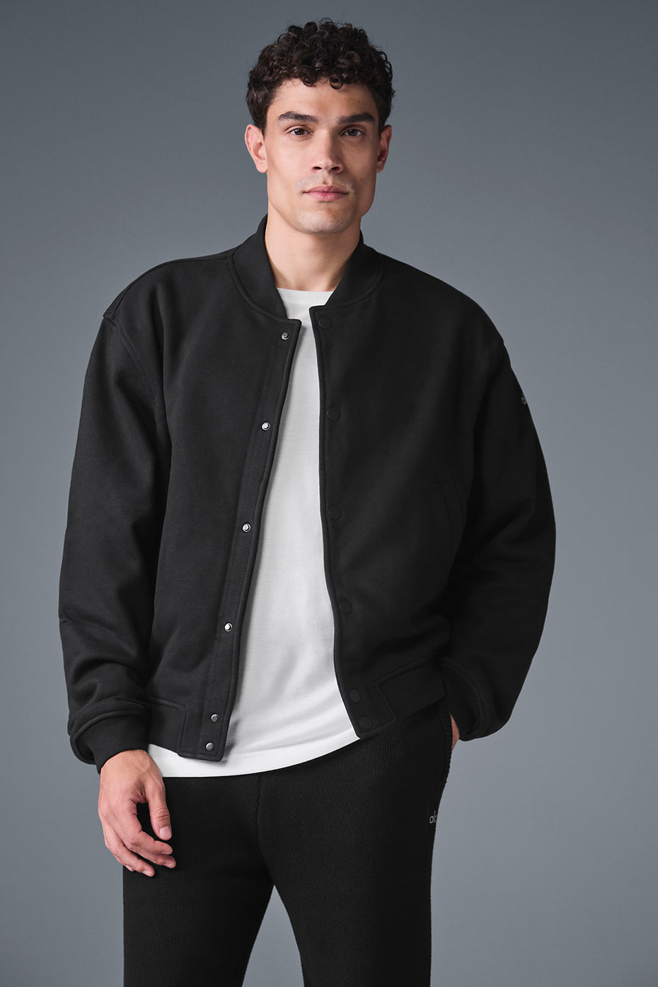 Model in Renown mens varsity jacket walking downtown during fall