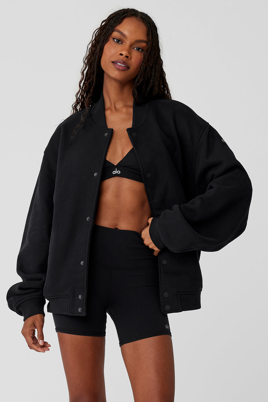 Close-up of black streetwear jacket button detail and terry texture