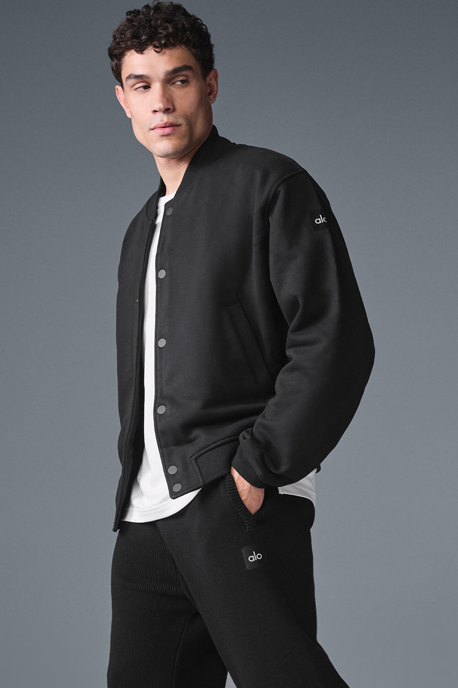 Model in Renown mens varsity jacket walking downtown during fall