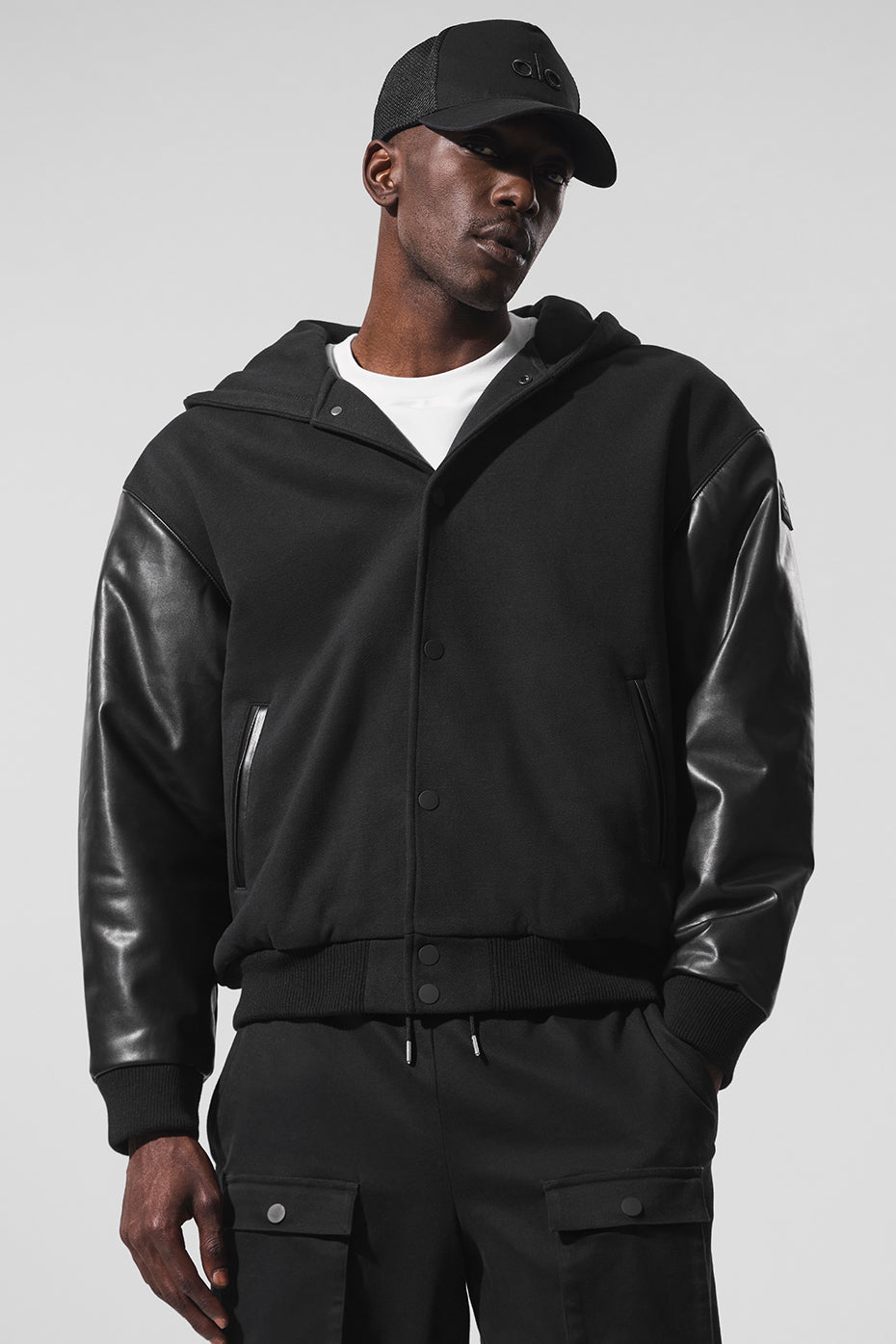 Front view of black bomber jacket with hood and matte snaps