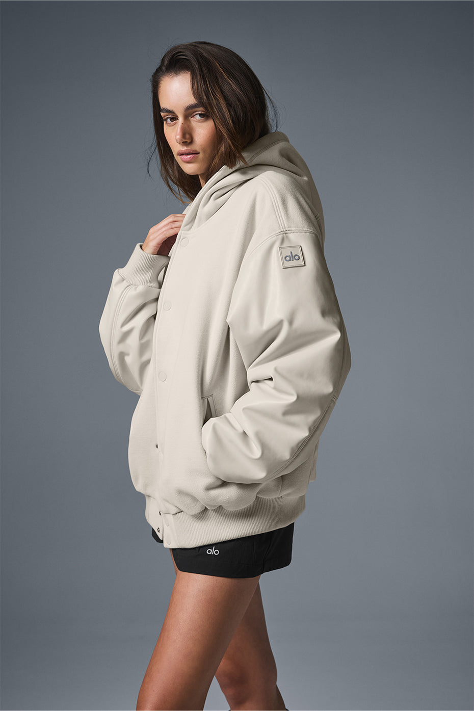 Side profile showing bomber jackets faux leather sleeves and ribbed cuffs