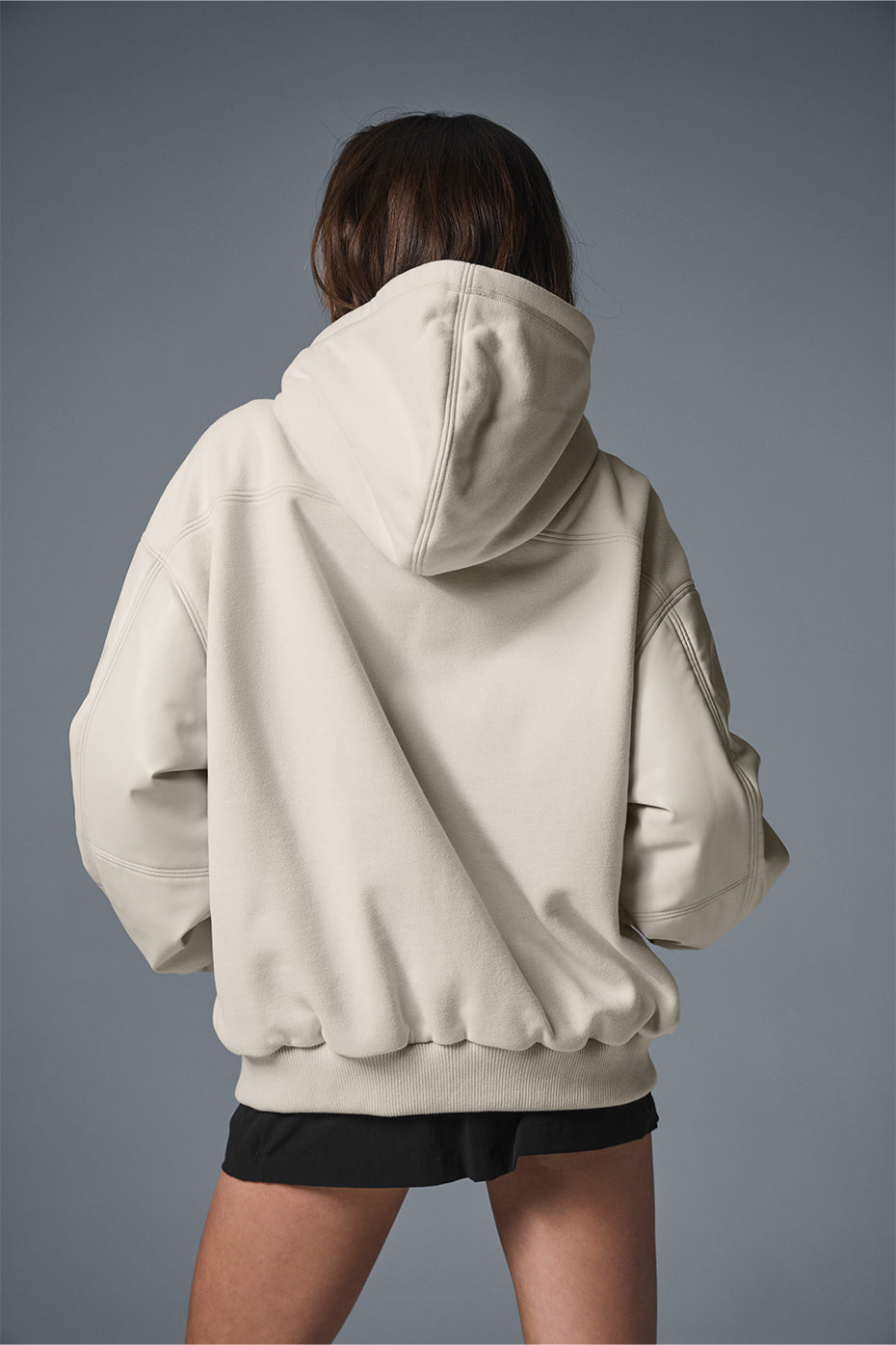 Front view of hooded jacket styled with urban winter layers