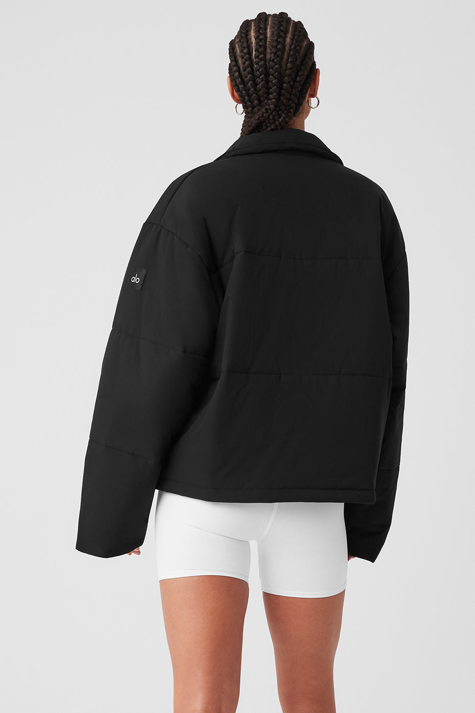 Side angle of black cargo jacket styled over hoodie for layering