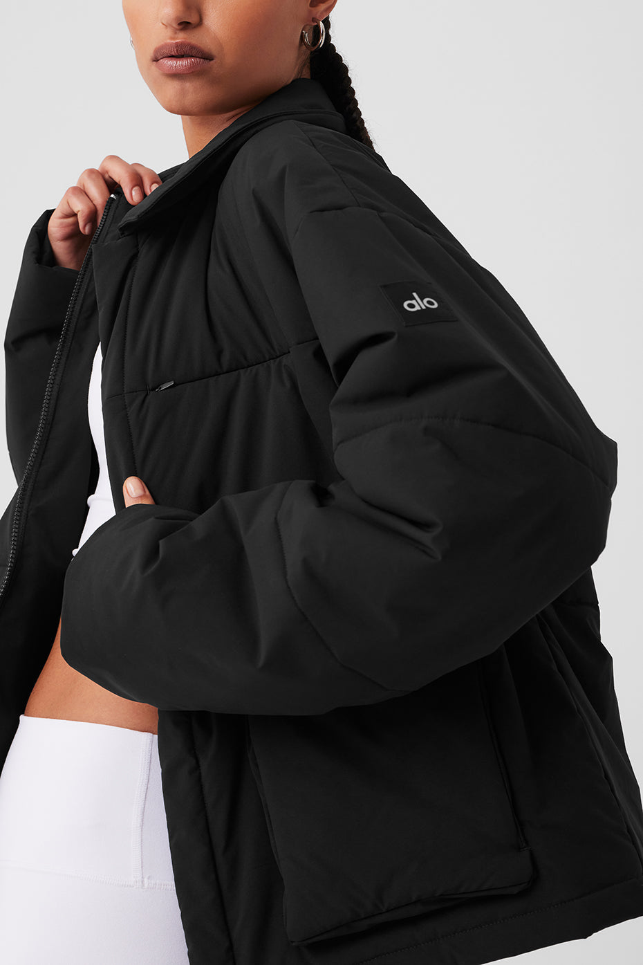 Side angle of black cargo jacket styled over hoodie for layering