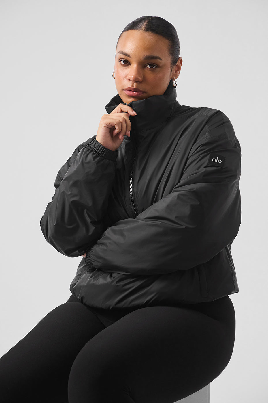 Back view of the lightweight down jacket, highlighting its oversized fit and banded hem.