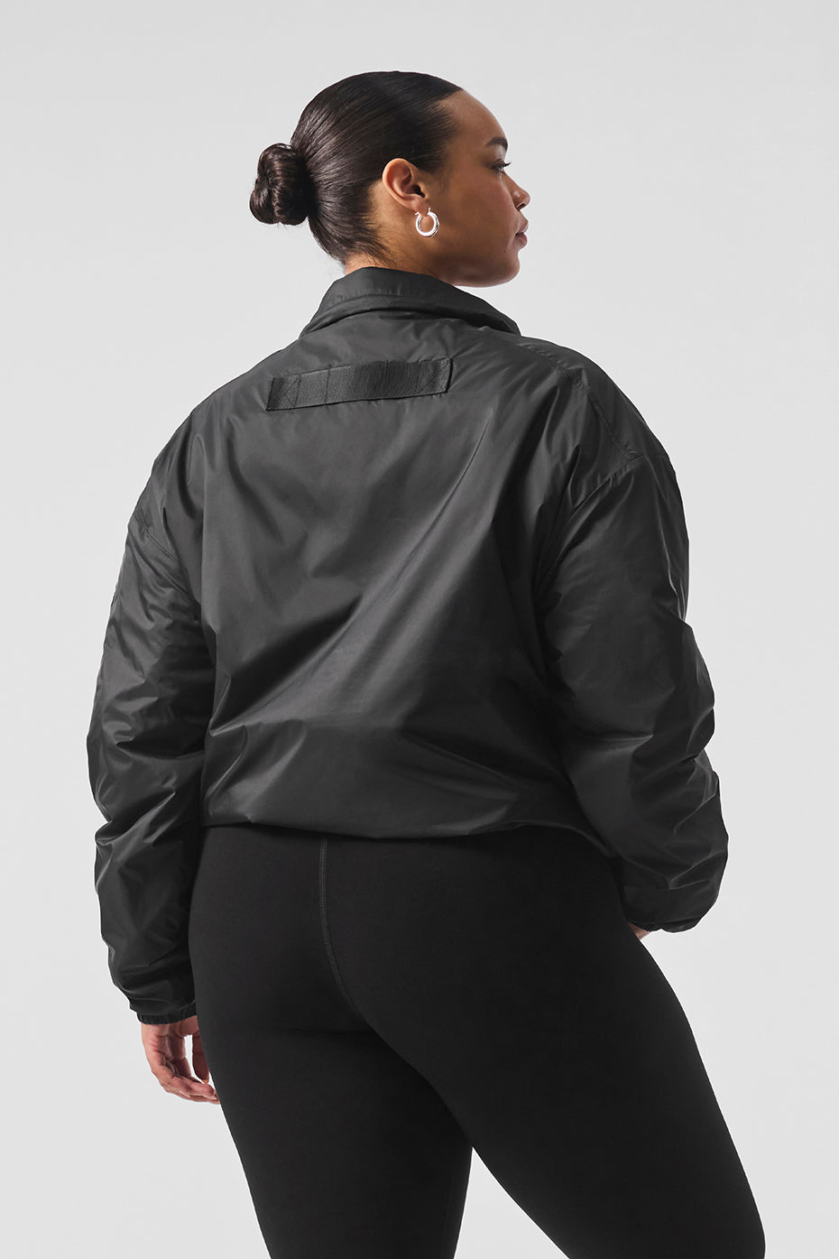 Front view of the Latitude lightweight running jacket in black, showcasing the half-zip collar.