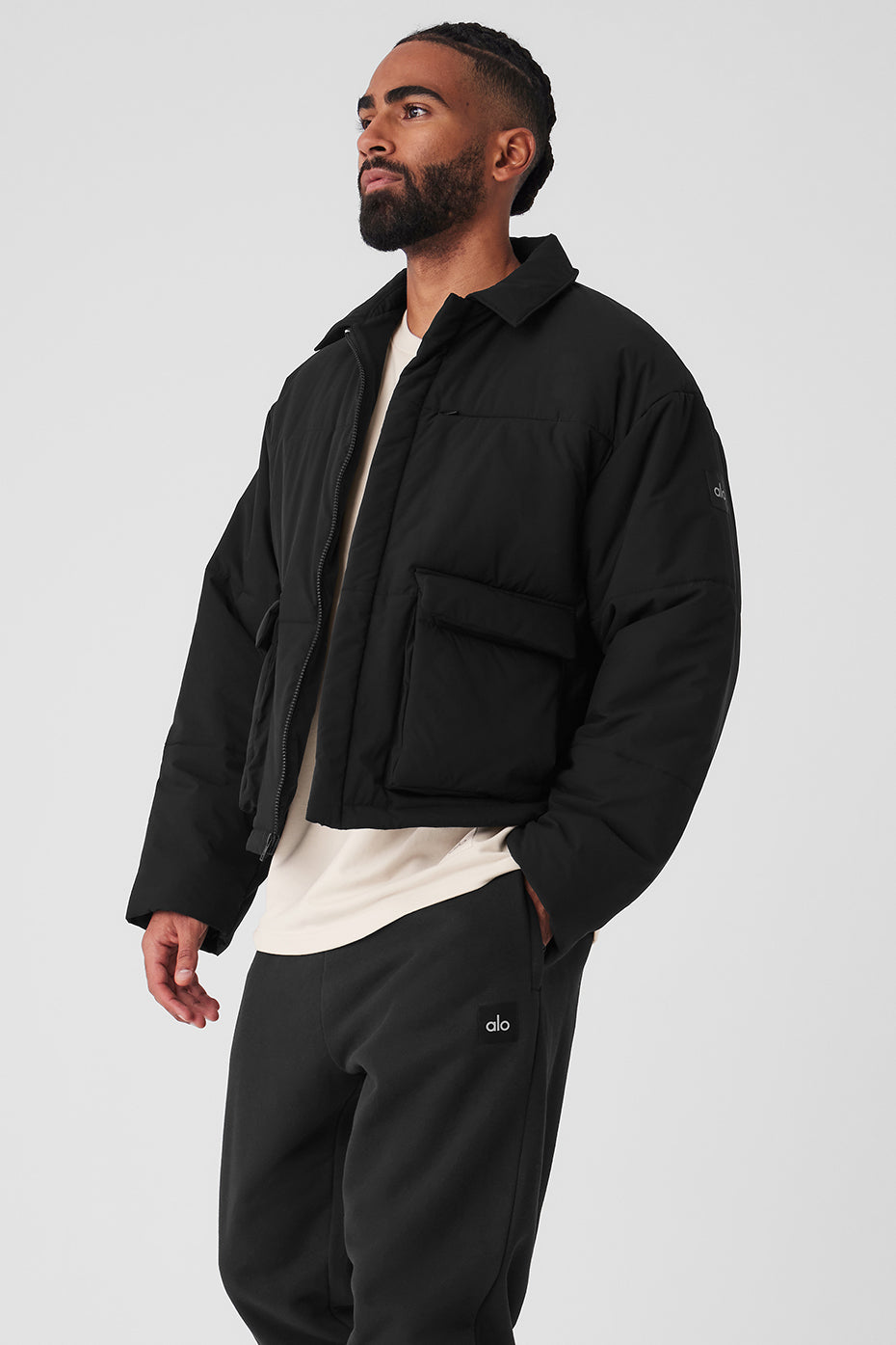 Model wearing the Voyage utility cargo jacket layered over a hoodie in an outdoor setting