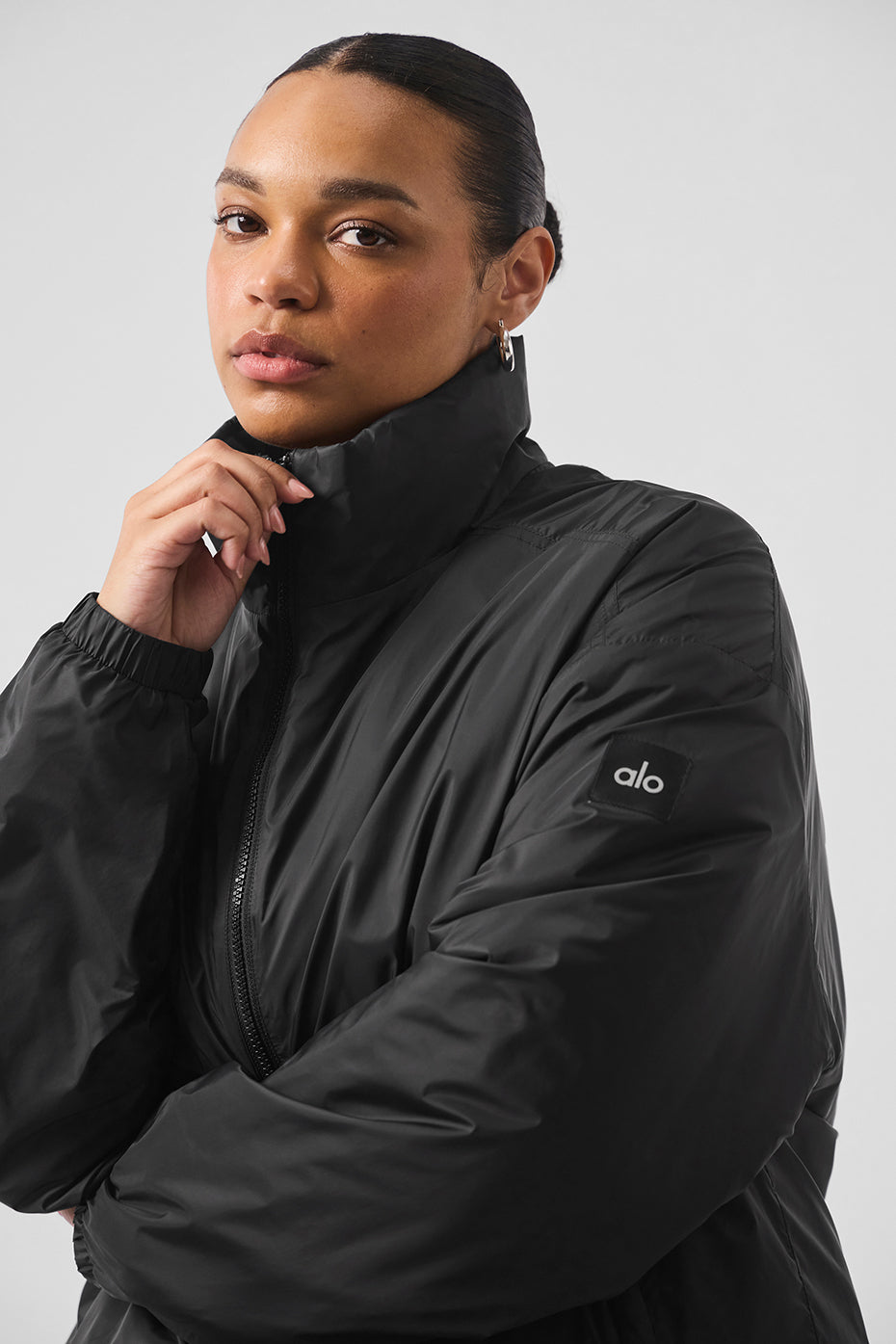 Front view of the Latitude lightweight running jacket in black, showcasing the half-zip collar.