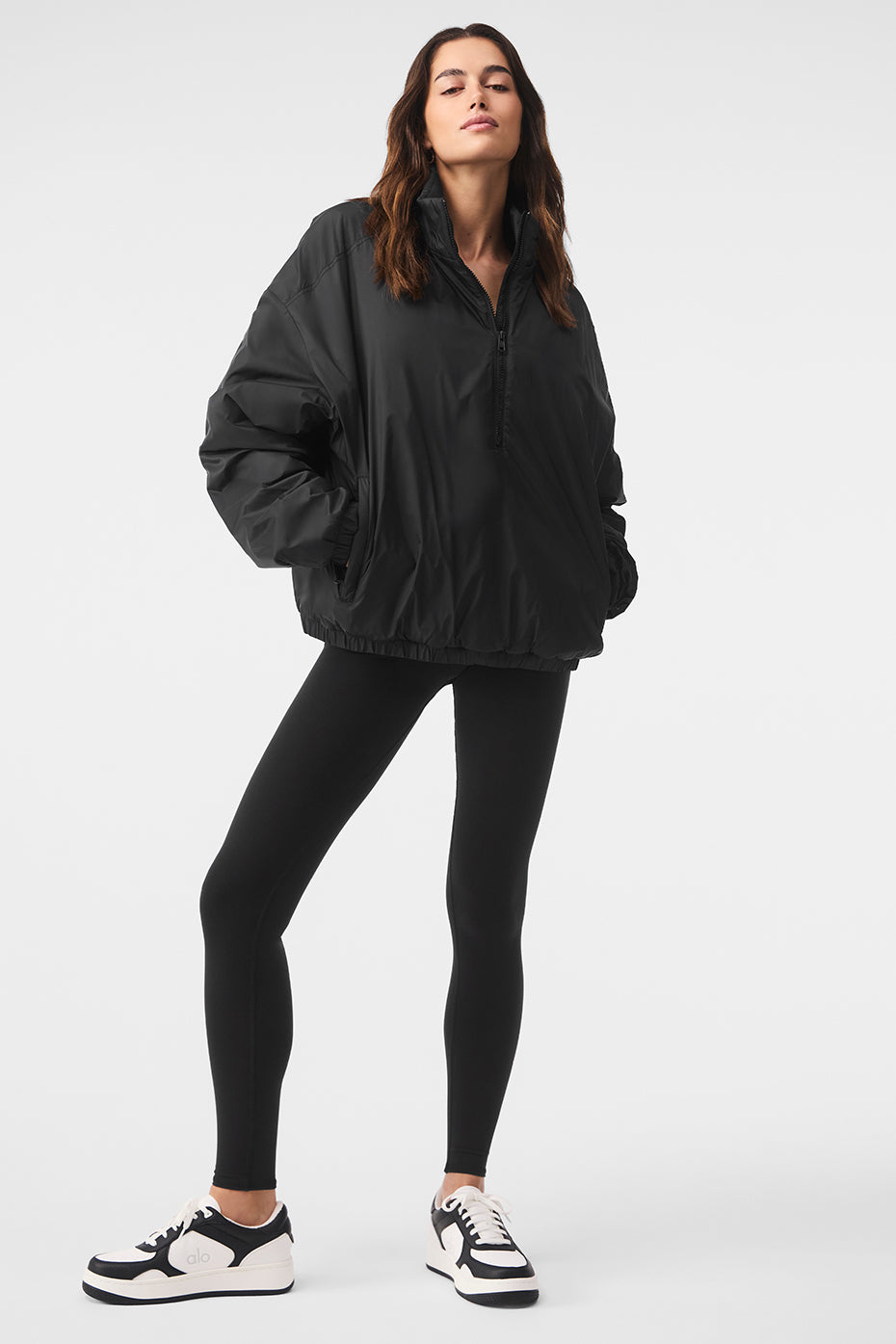 Front view of the Latitude lightweight running jacket in black, showcasing the half-zip collar.