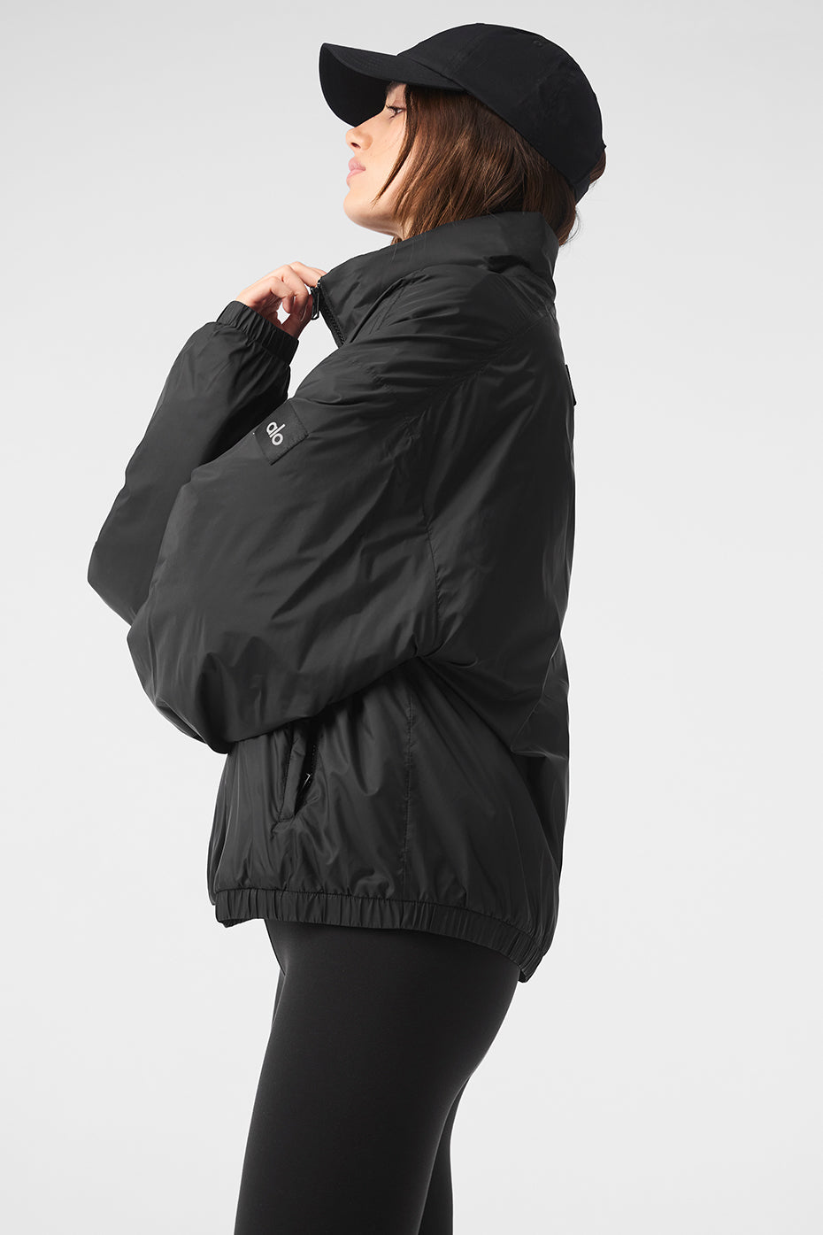 Front view of the Latitude lightweight running jacket in black, showcasing the half-zip collar.