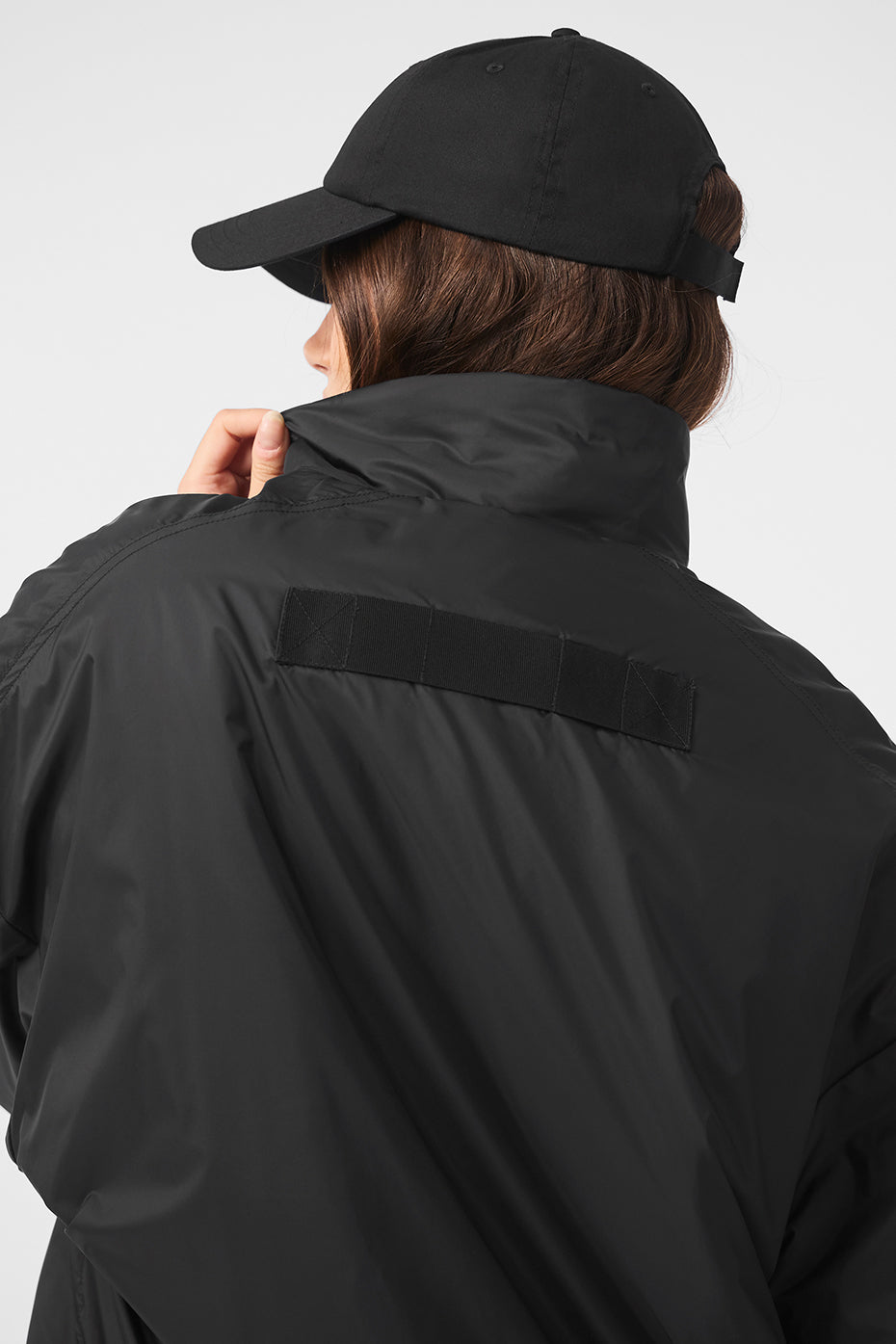 Side view of the black pullover jacket with zippered pockets, perfect for rainy runs.