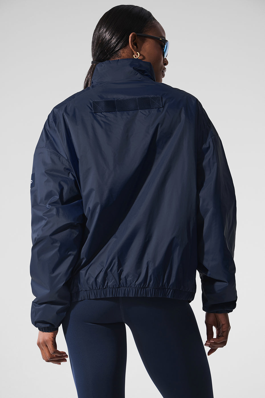 Runner wearing the lightweight jacket on a misty forest trail.