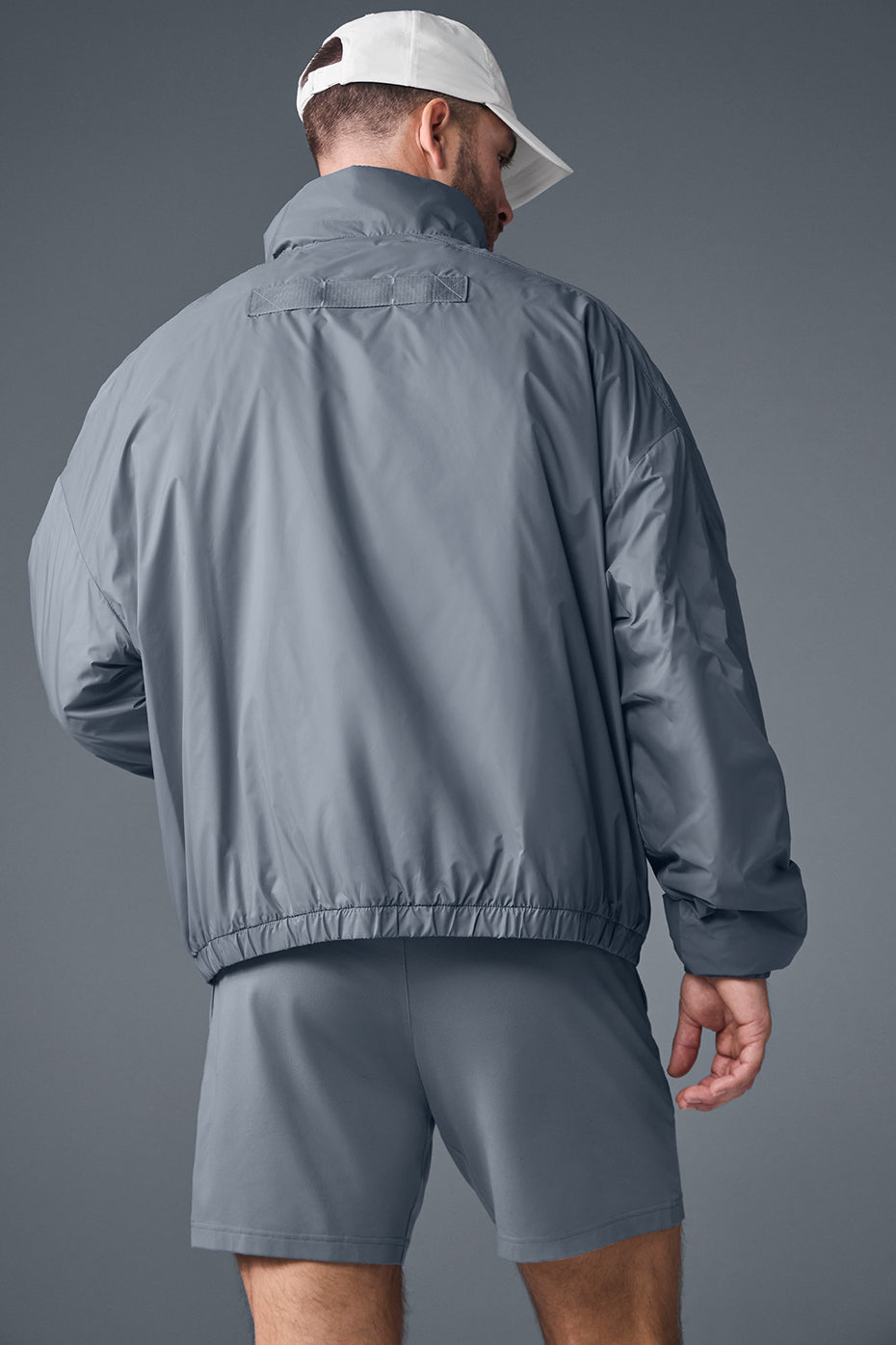Side profile of half-zip jacket with zippered pockets and banded cuffs