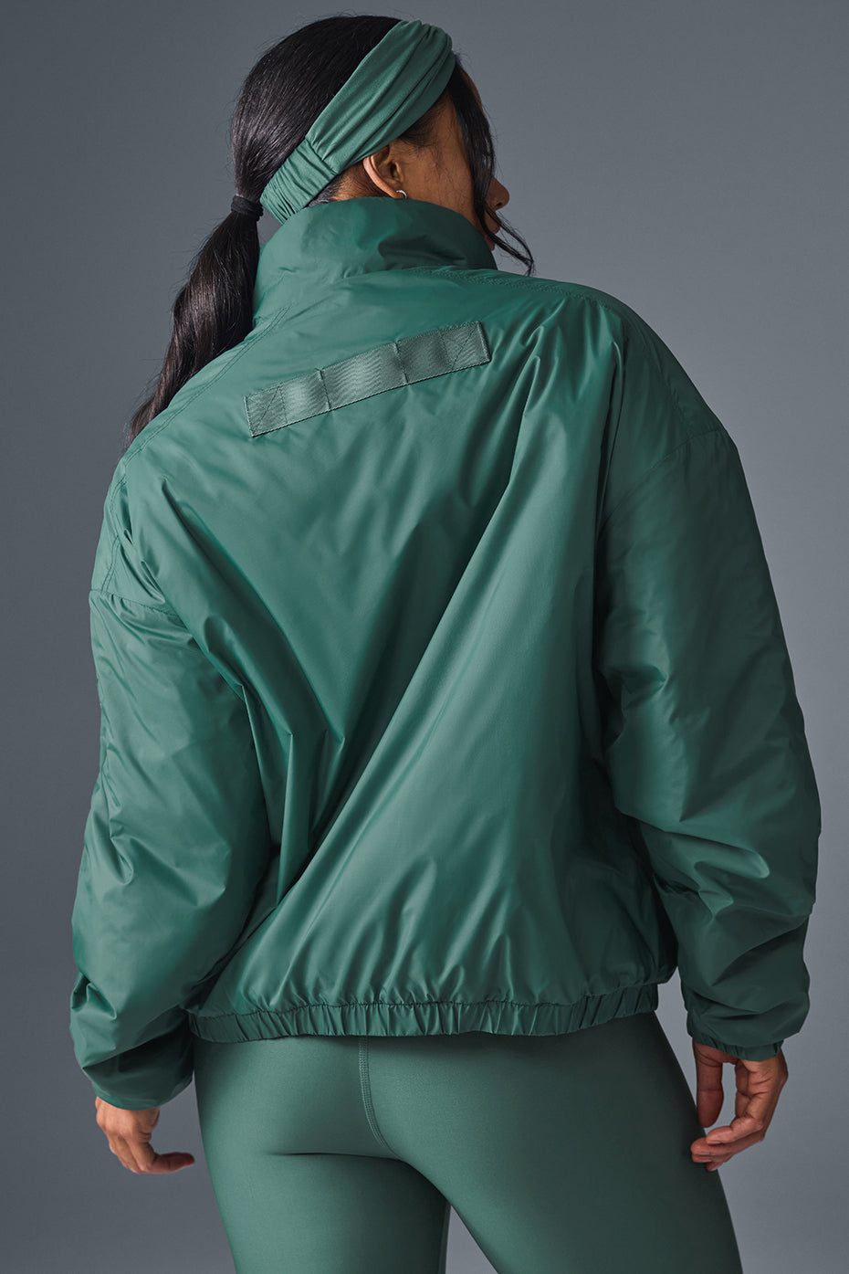 Model showcasing the waterproof running jacket during a jog.