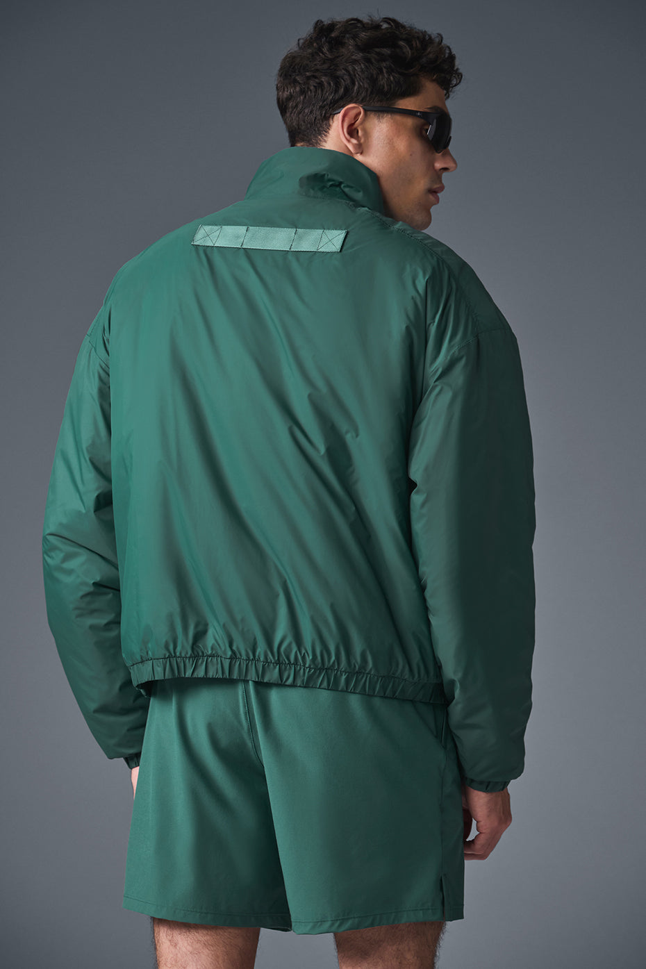 Side profile of the pullover jacket showing banded cuffs and hem in outdoor setting