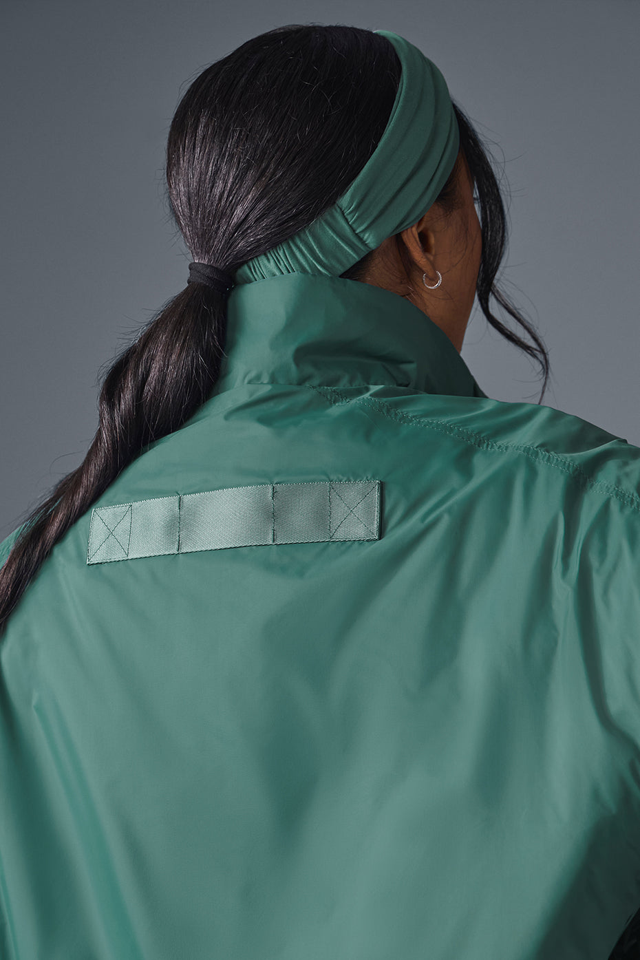 Model showcasing the waterproof running jacket during a jog.