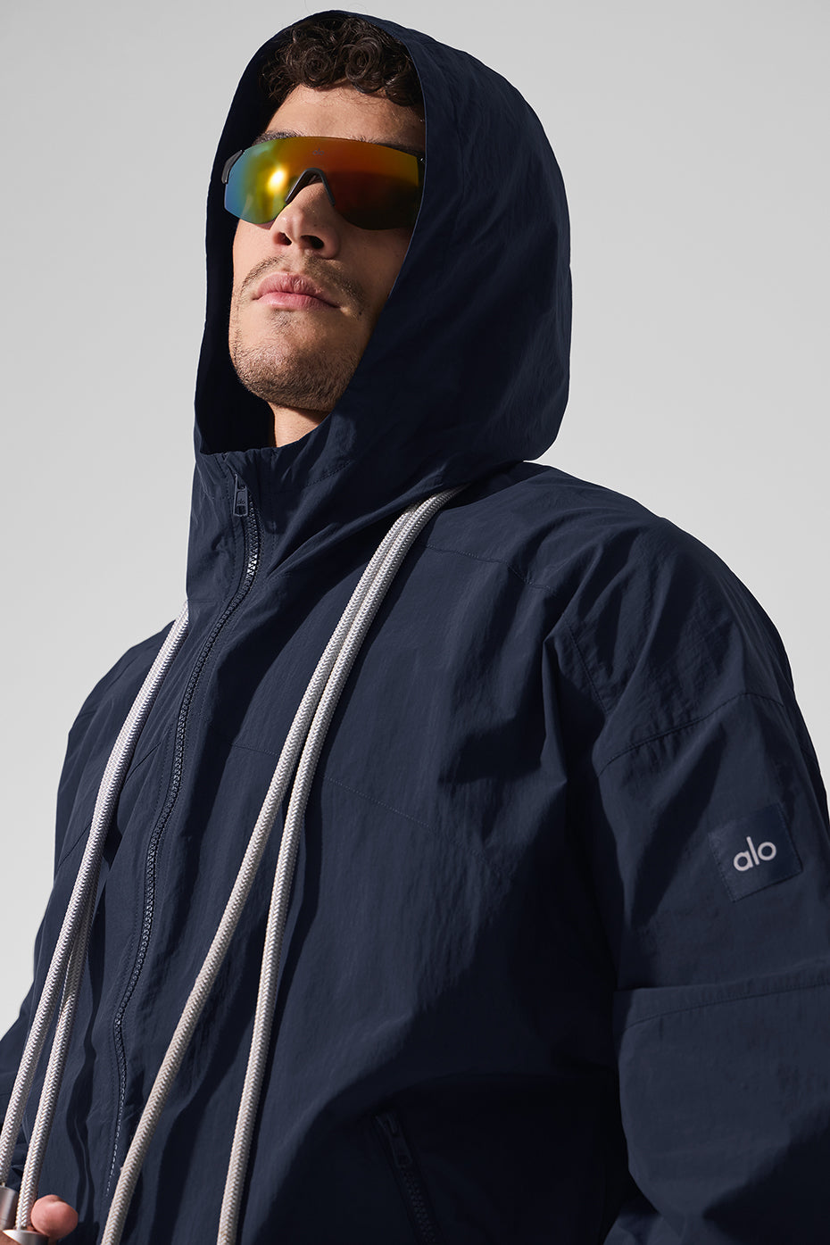 Side view showcasing the structured hood and full-zip front of the mens windbreaker.