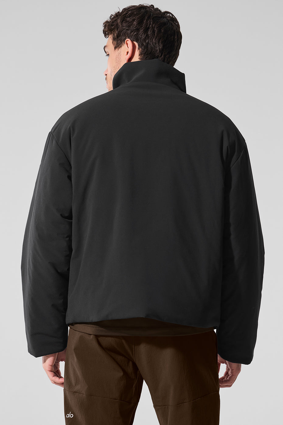 Model wearing the black bomber jacket layered over a casual outfit.