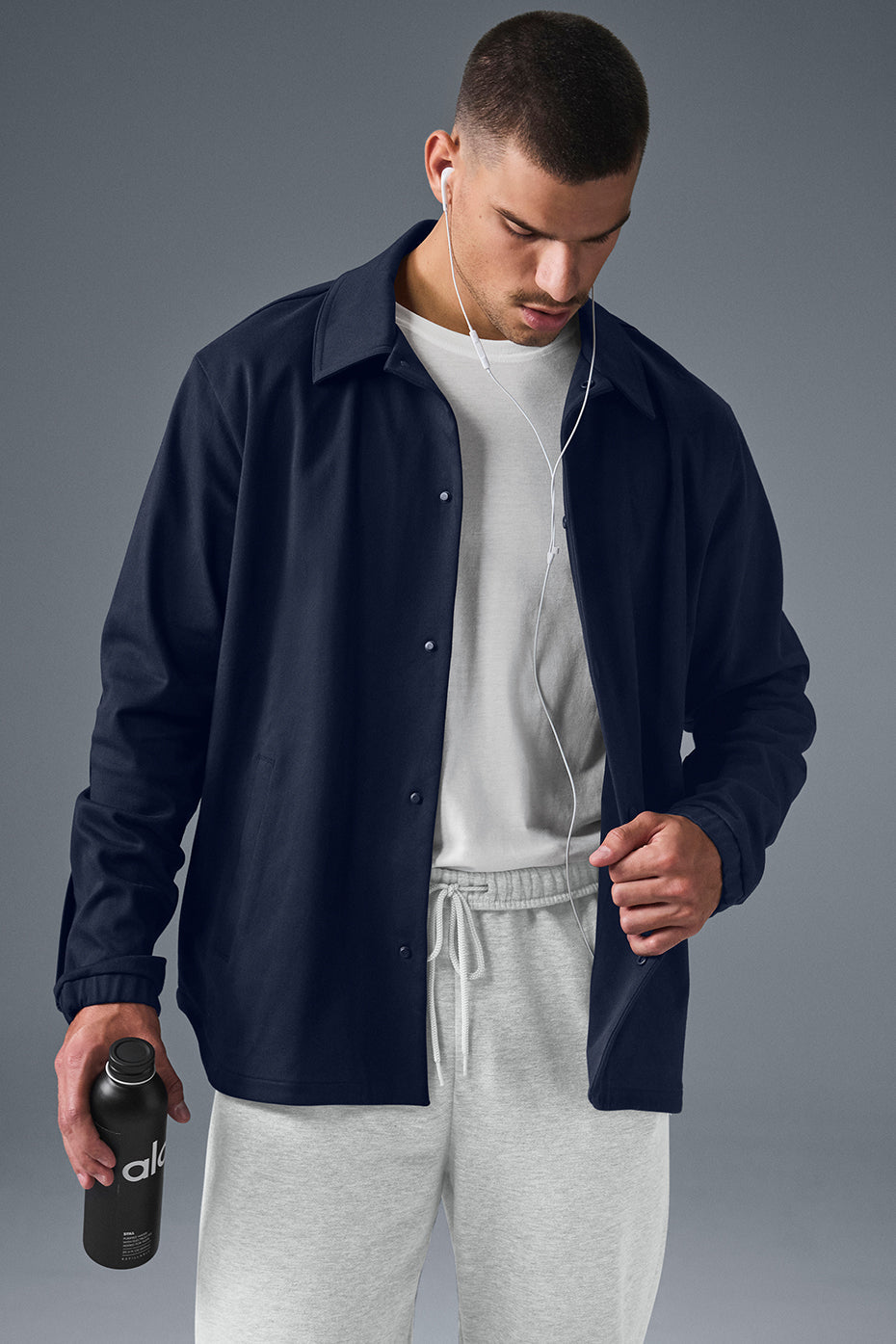 Front profile of navy suede bomber jacket hanging on an oak wall hook