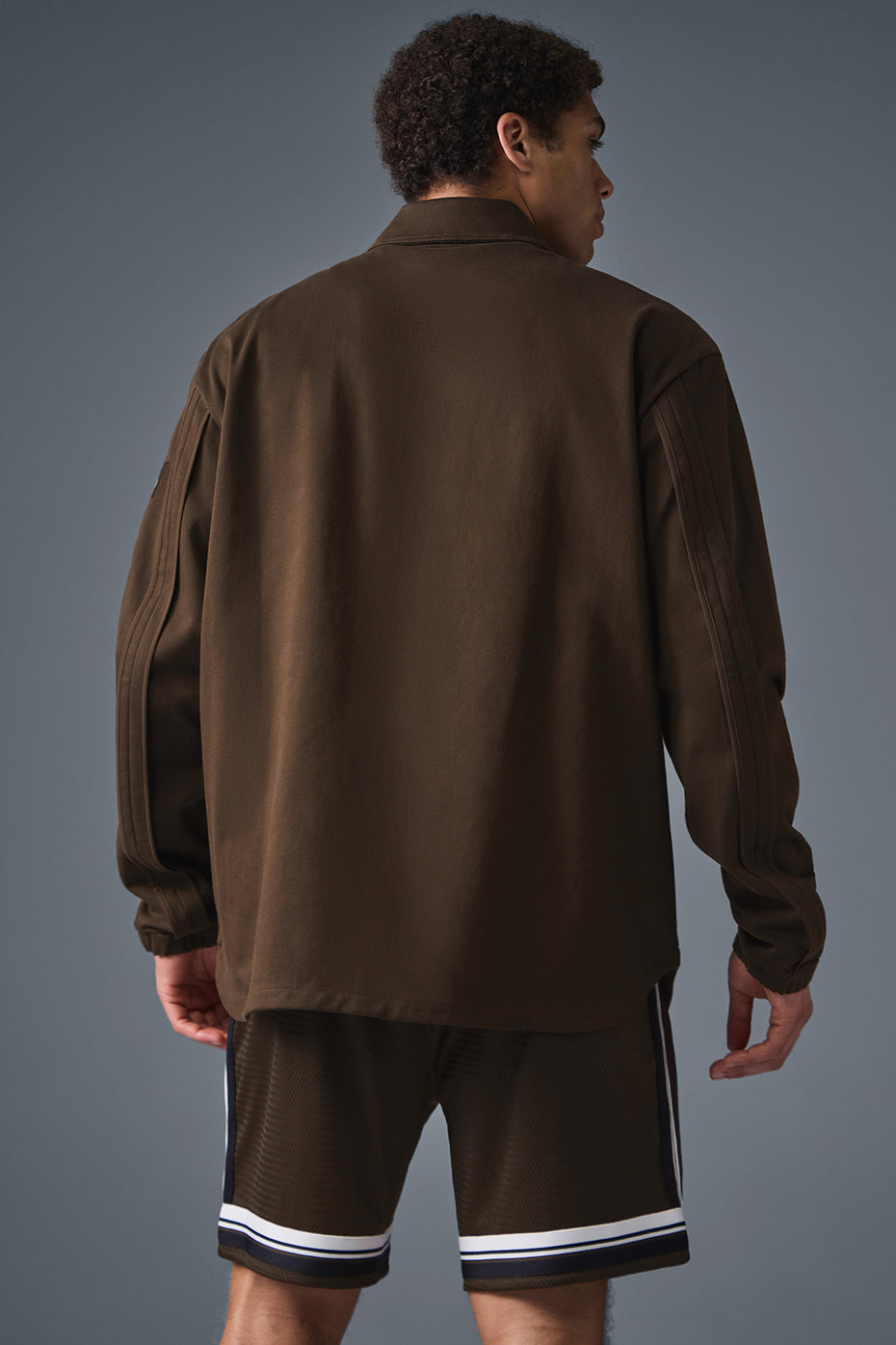 Side angle of the stylish outerwear jacket, highlighting the unique seaming.