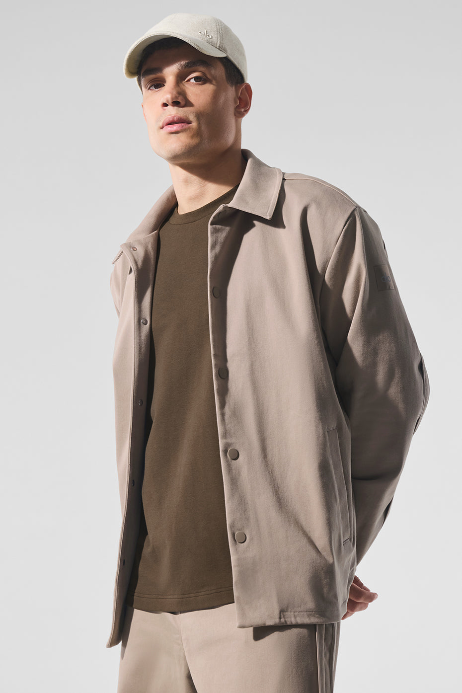 Front view of the gravel suede bomber jacket on model showing structured fit and snap buttons
