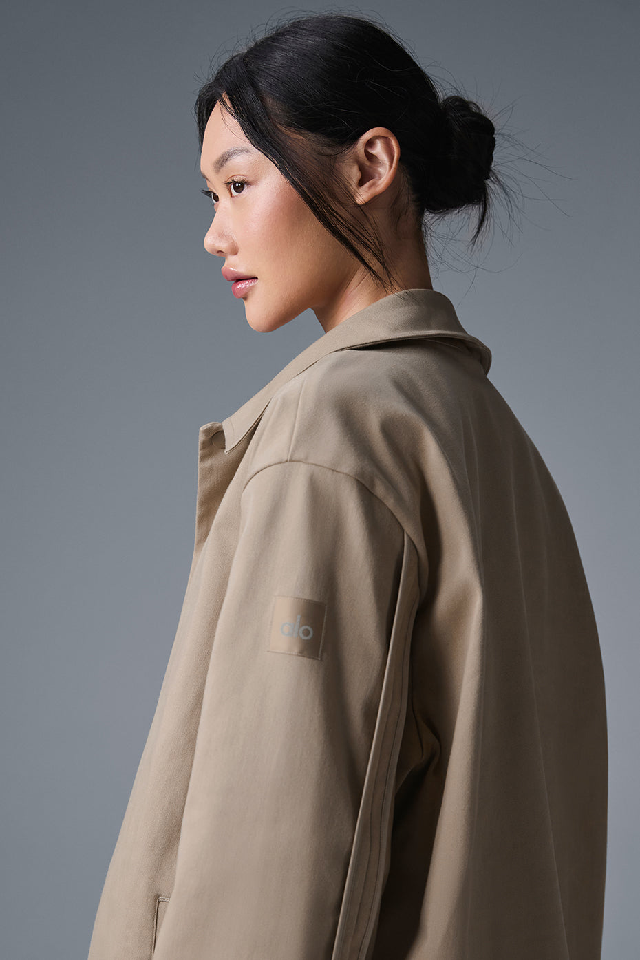 Close-up of the brown suede bomber jacket showcasing the textured fabric.