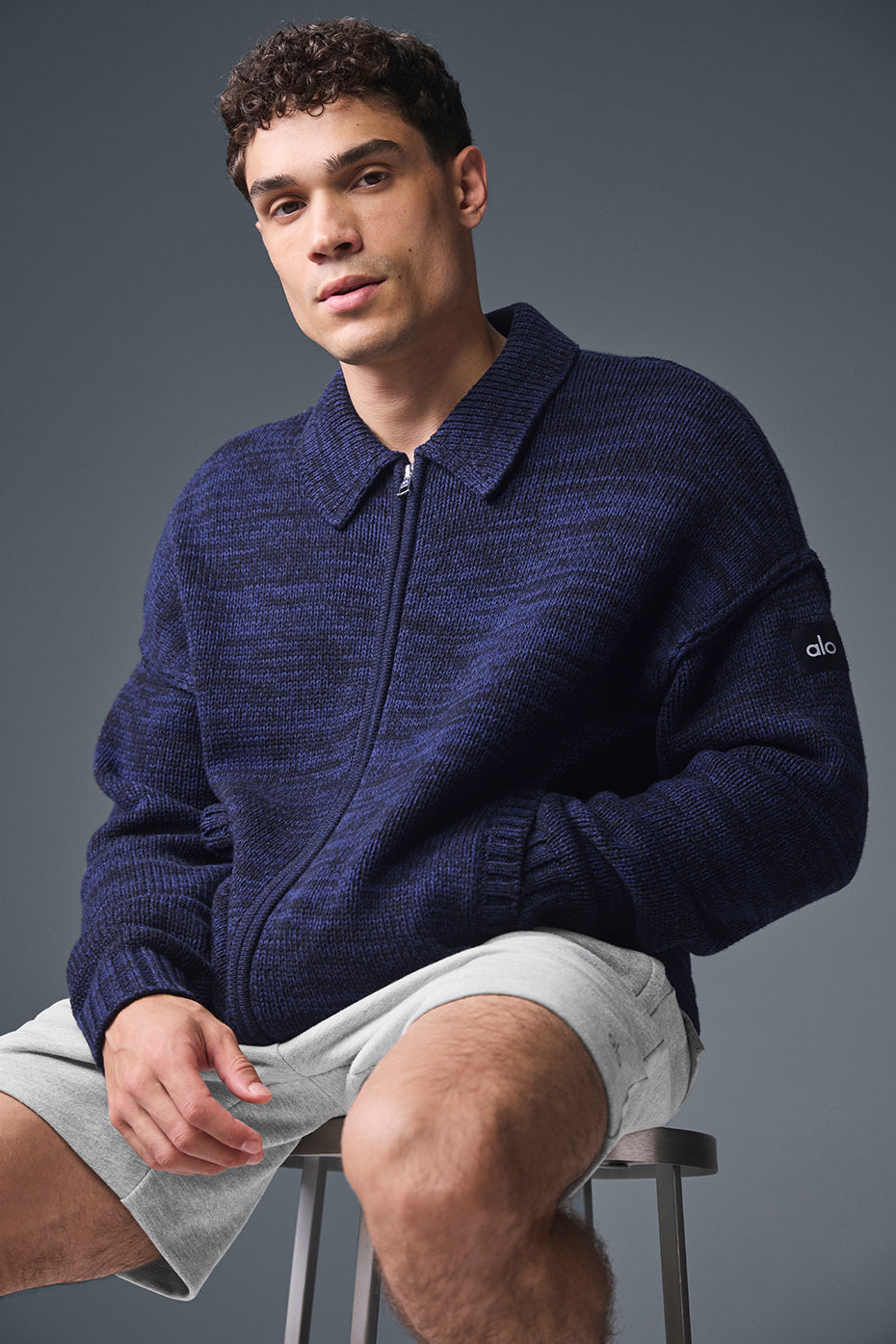 Model wearing the cashmere sweater layered over casual shirt for a relaxed look
