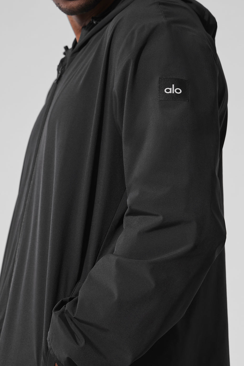 Side view of the black performance jacket worn during a gym workout.