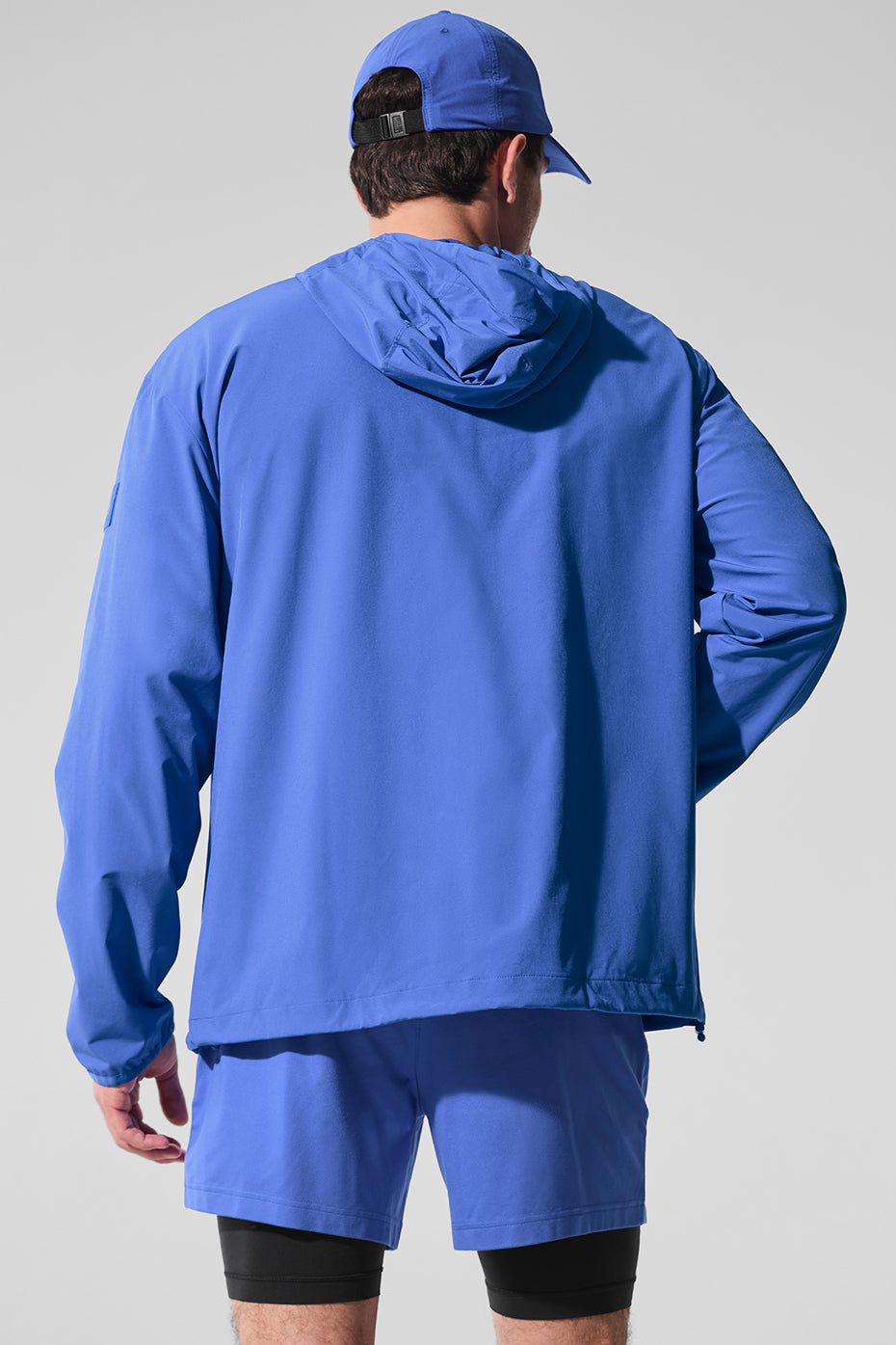 Model wearing the running rain jacket during a morning jog in a park.