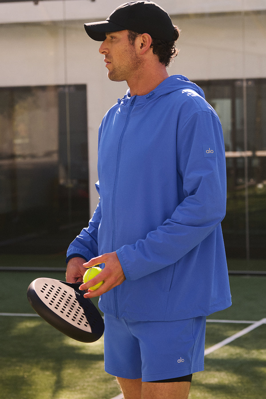 Model wearing the running rain jacket during a morning jog in a park.