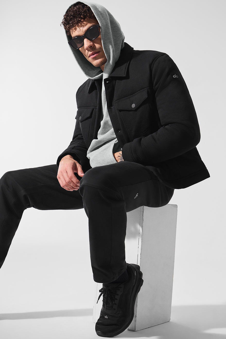 Side view of the black trucker jacket, highlighting the pockets and fit.