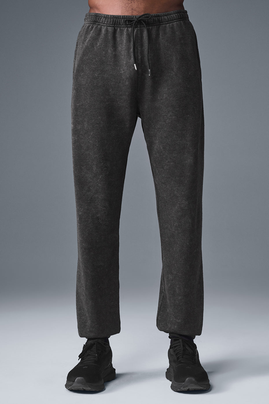 Front view of baggy sweatpants with vintage wash, styled with white sneakers
