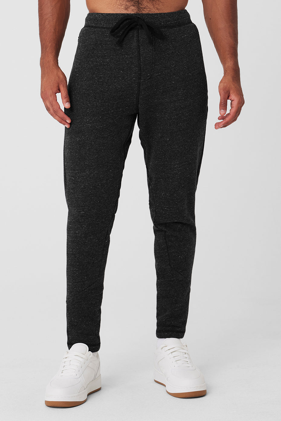 Front angle of men's workout pants with zip pockets and ribbed calves